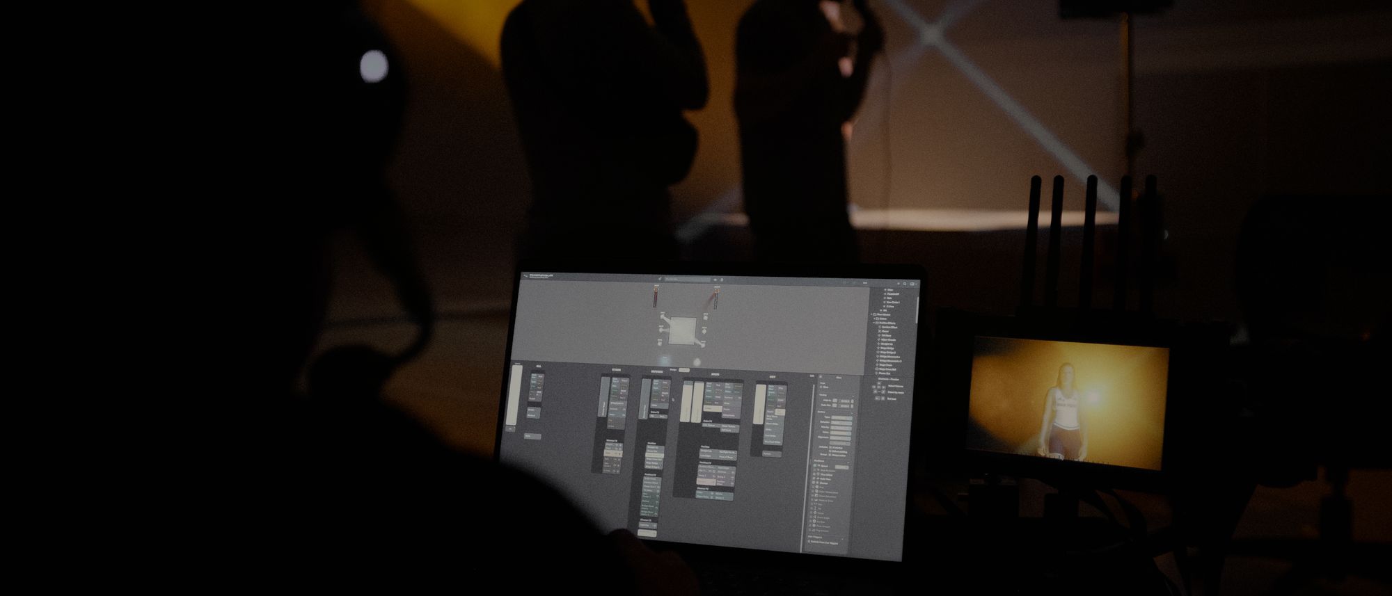 Crew members silhouetted at a monitor station while lighting cues play across a darkened set