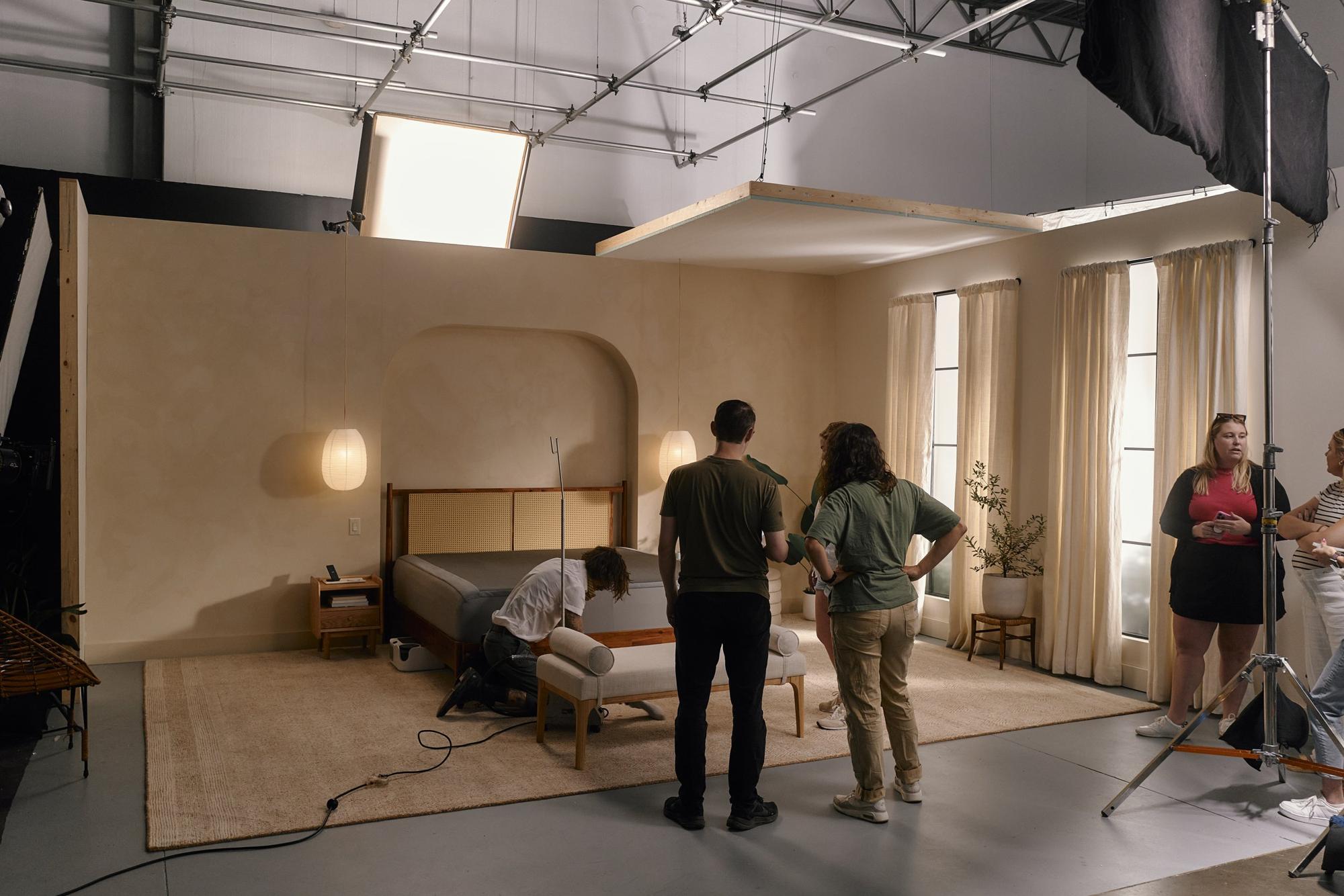 A full bedroom set built inside the studio, with crew preparing a camera crane